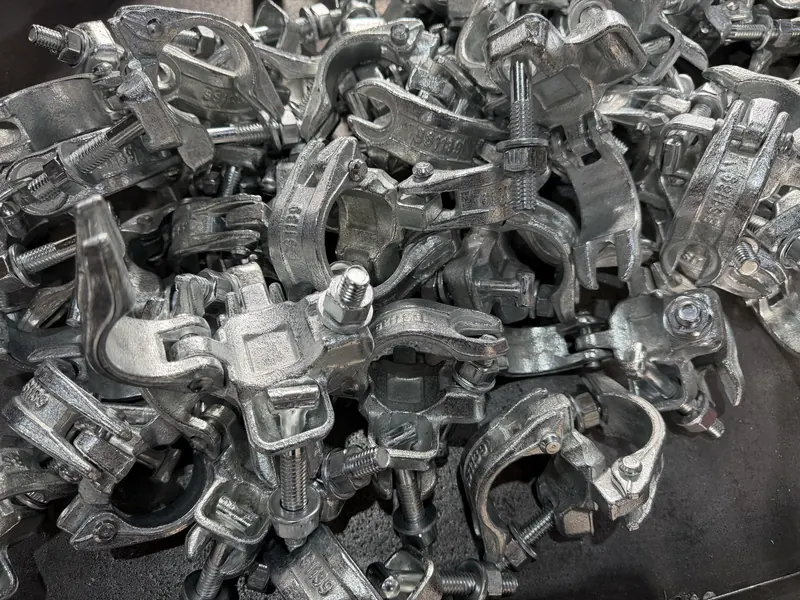 Pile of assembled drop-forged scaffold couplers with bolts and nuts
