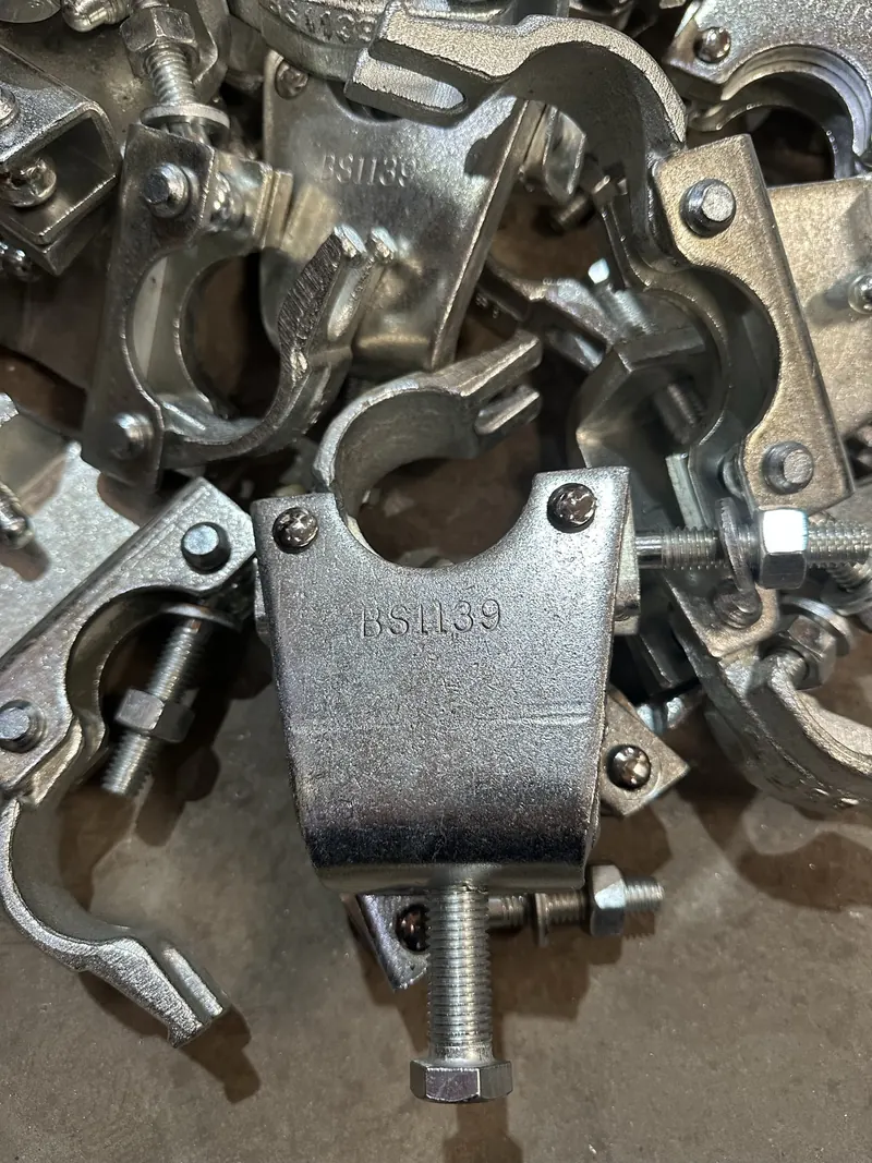 Close-up of assembled galvanised couplers in a pile, one marked BS1139