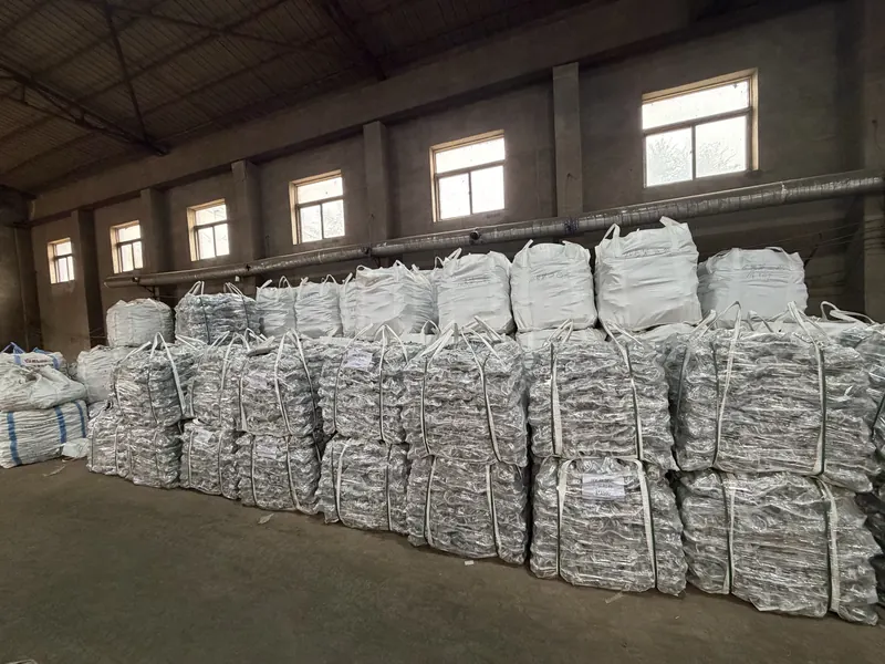 Stacked woven bags of couplers and bulk bags in a factory warehouse
